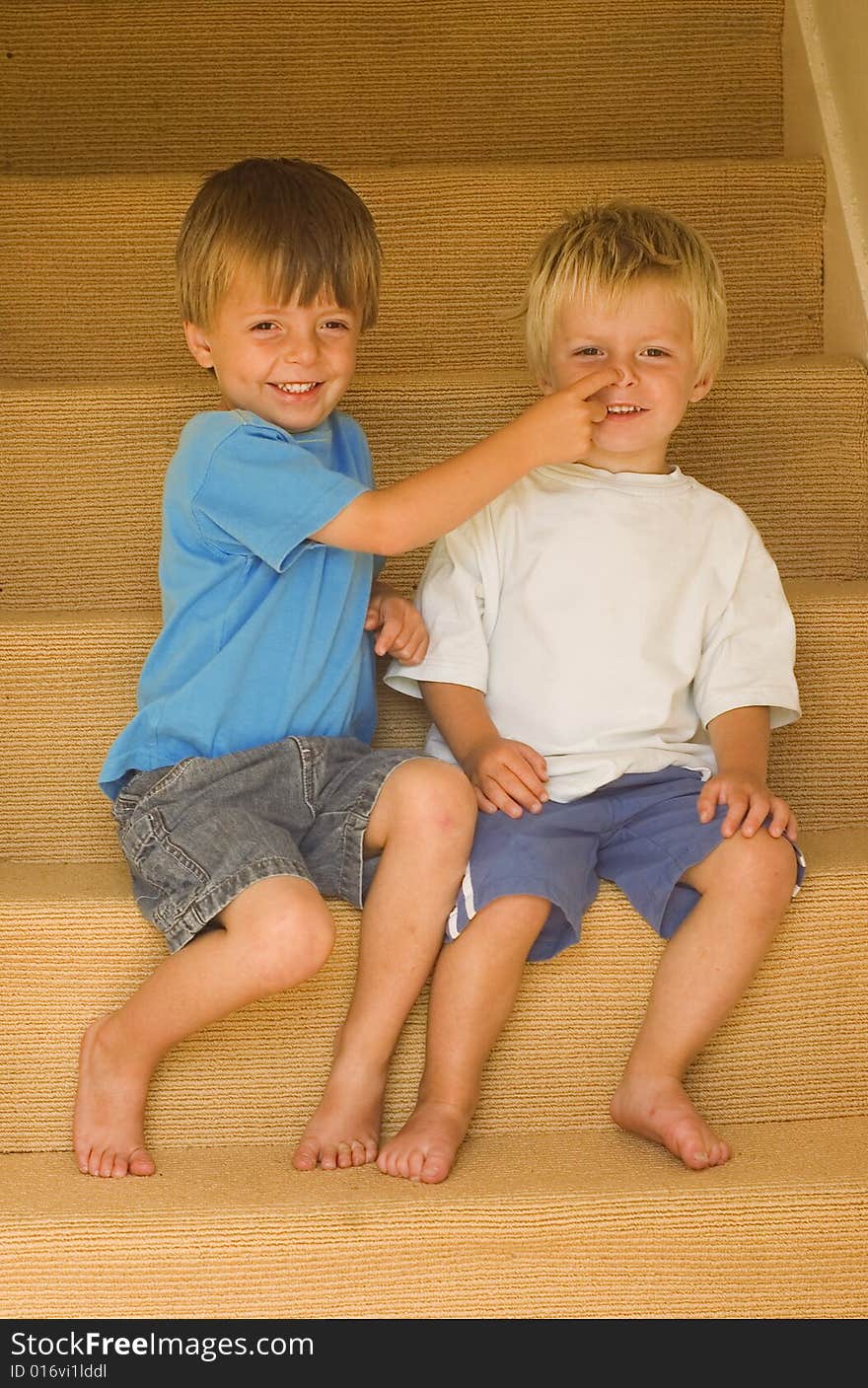 Brothers playing on the stairs having fun.