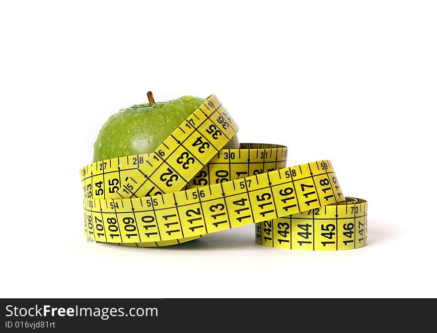 Green apple and tape measure on white