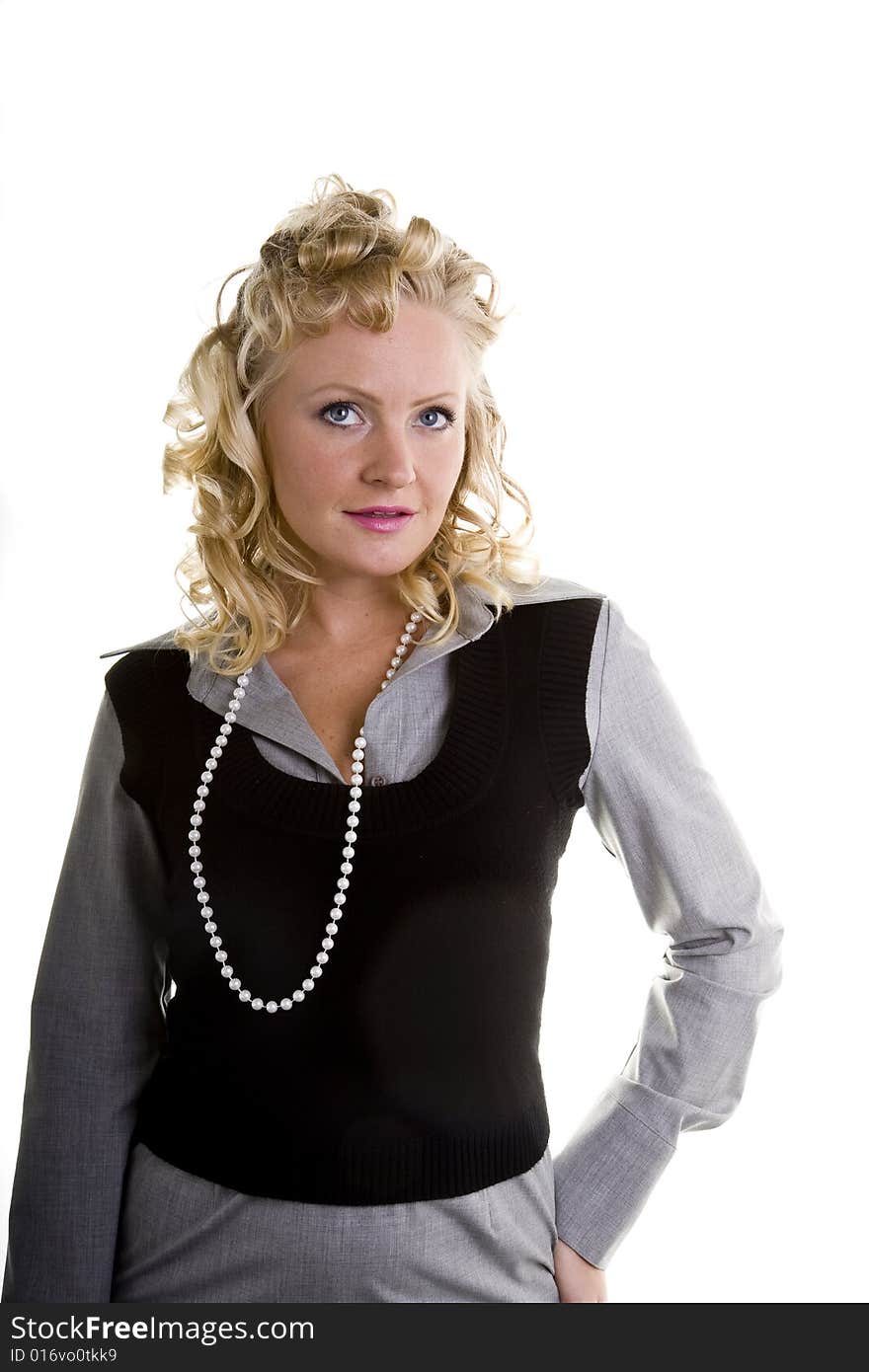 A curly blonde model with pearls and one hand on her hip. A curly blonde model with pearls and one hand on her hip