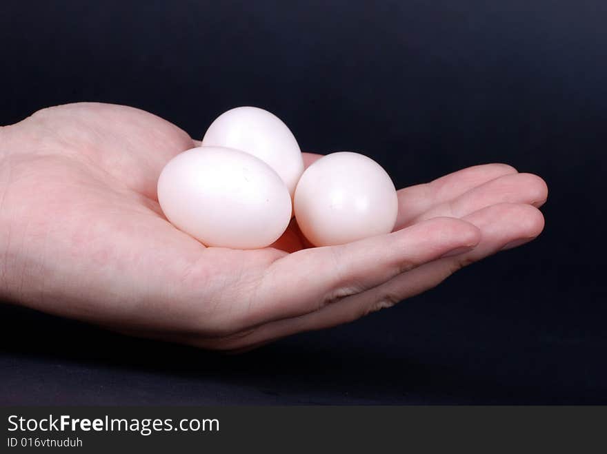 Group of eggs in  hand isolated on black background. Group of eggs in  hand isolated on black background