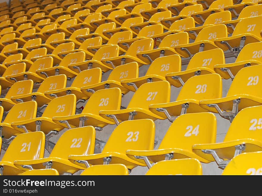 The yellow block of seats in stadium. All seats are numbered.