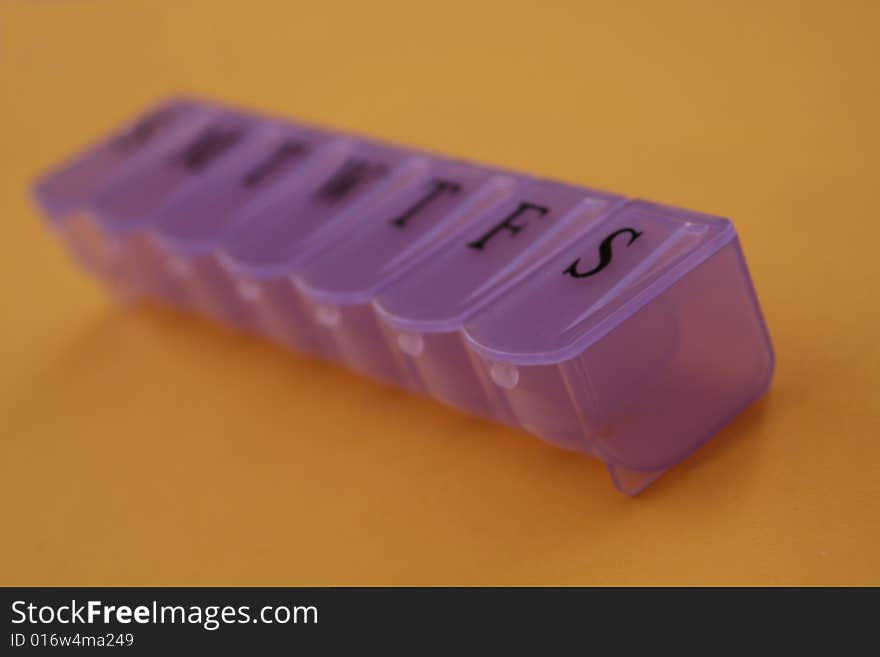 Purple Pill Container On Gold Table