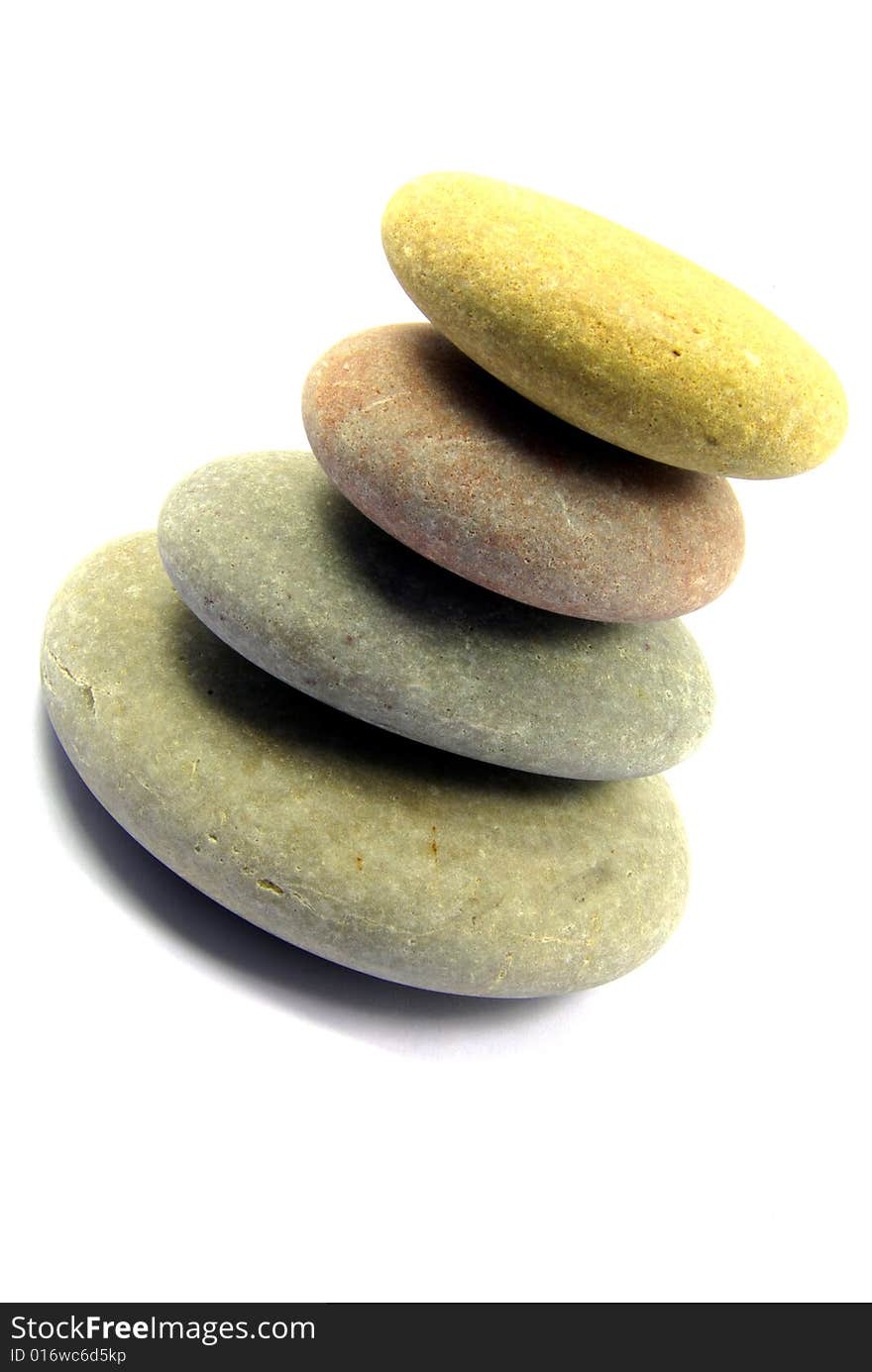 Close-up view on a pyramid of four pebbles over a white background. Close-up view on a pyramid of four pebbles over a white background.