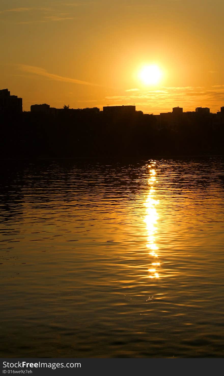 Silhouette of city in sunset on the coast of sea