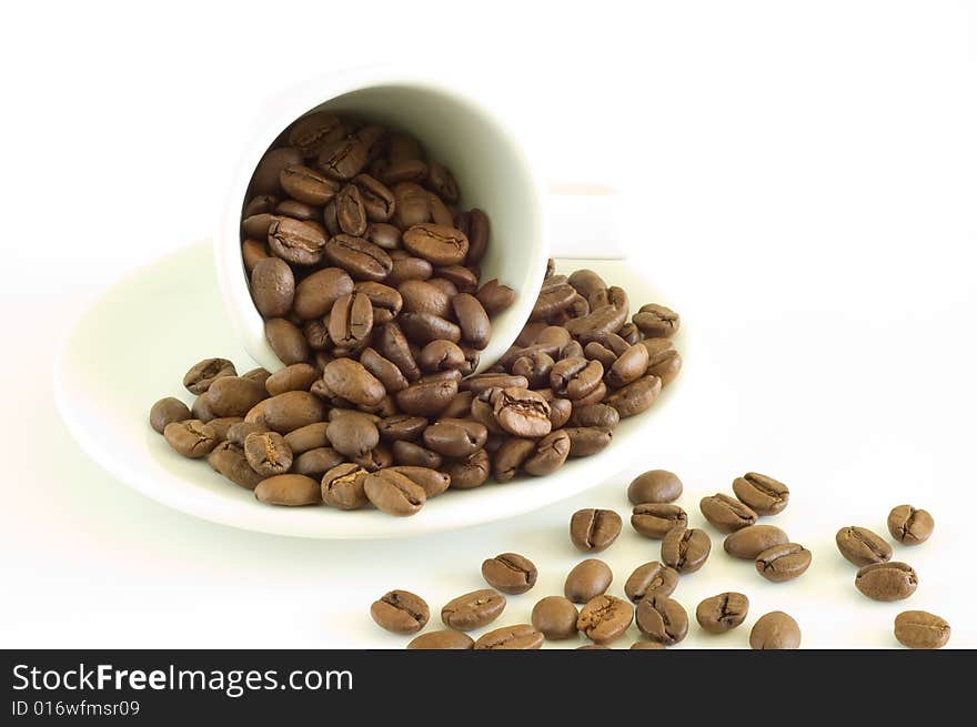 White coffee cup and coffee beans on a light background