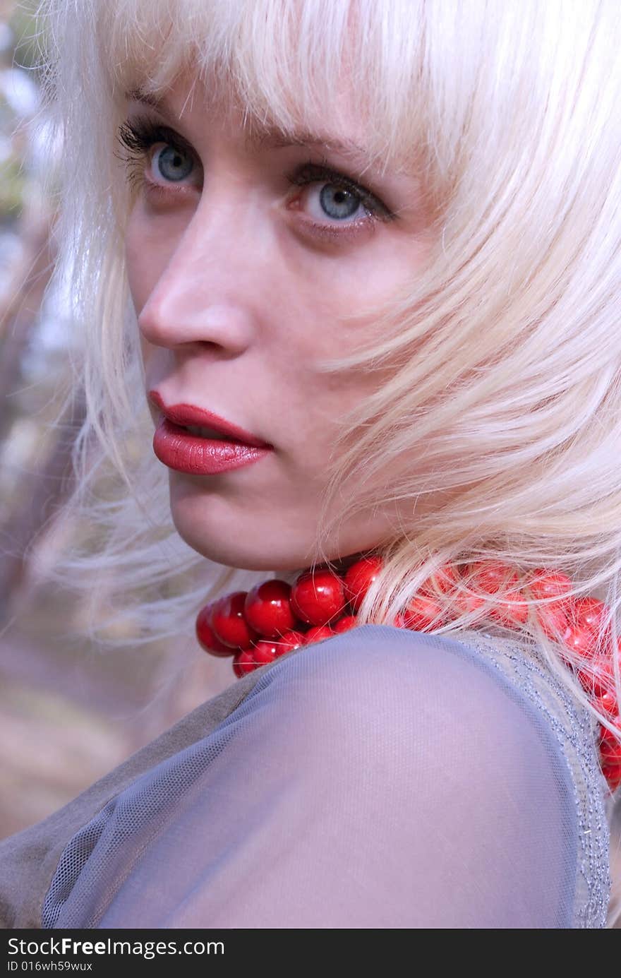 A portrait of a young pretty woman wearing red beads