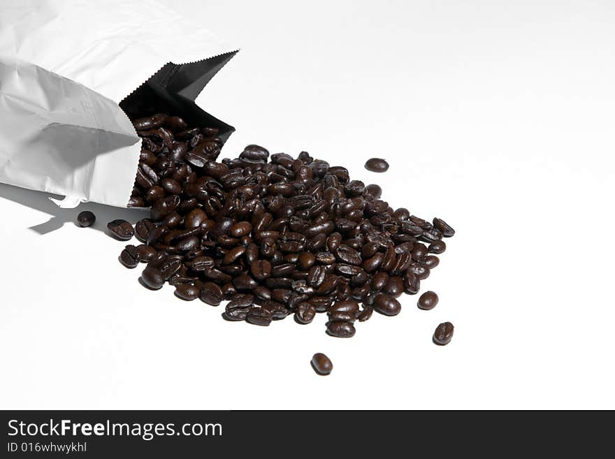 A bag of coffee beans spilled isolated on white