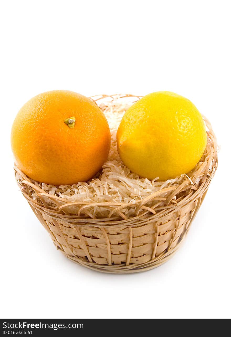 Yellow lemon in basket together with beautiful tasty orange on white background. Yellow lemon in basket together with beautiful tasty orange on white background