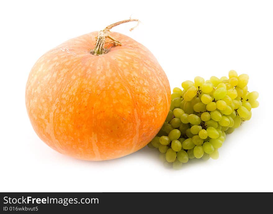 Orange pumpkin and green sweet tasty grapes on white background