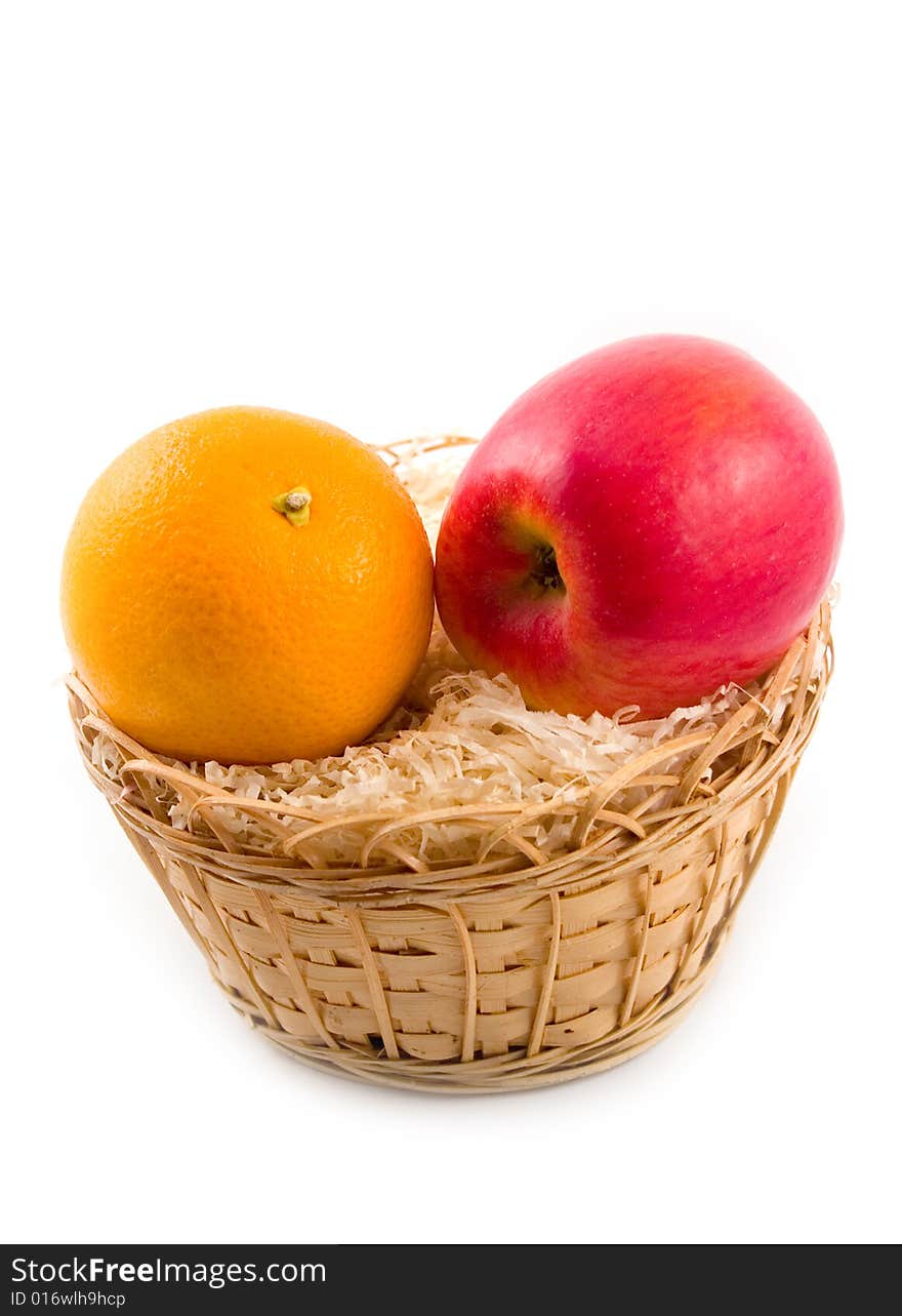 Beautiful orange and tasty red plant apple in yellow basket on white background