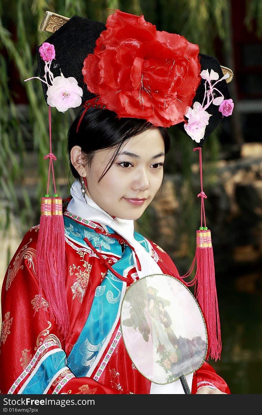 A beautiful girl in Chinese ancient dress is in the royal garden. This is dress of Qing Dynasty of China. It is the princess' dress too. Chinese on the fan is meant and missed. A beautiful girl in Chinese ancient dress is in the royal garden. This is dress of Qing Dynasty of China. It is the princess' dress too. Chinese on the fan is meant and missed.