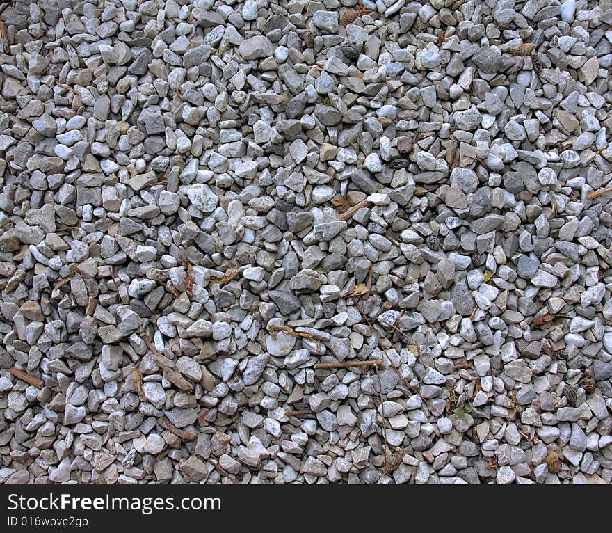 Gravel surface with dry autumn leaves and sticks on. Gravel surface with dry autumn leaves and sticks on.