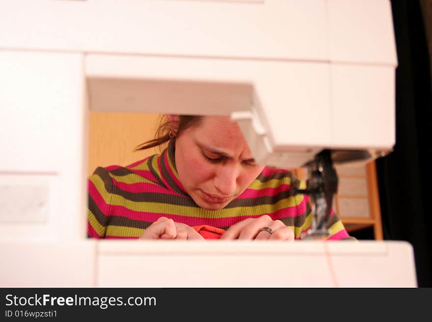 Needlewoman working with her sewing-machine.