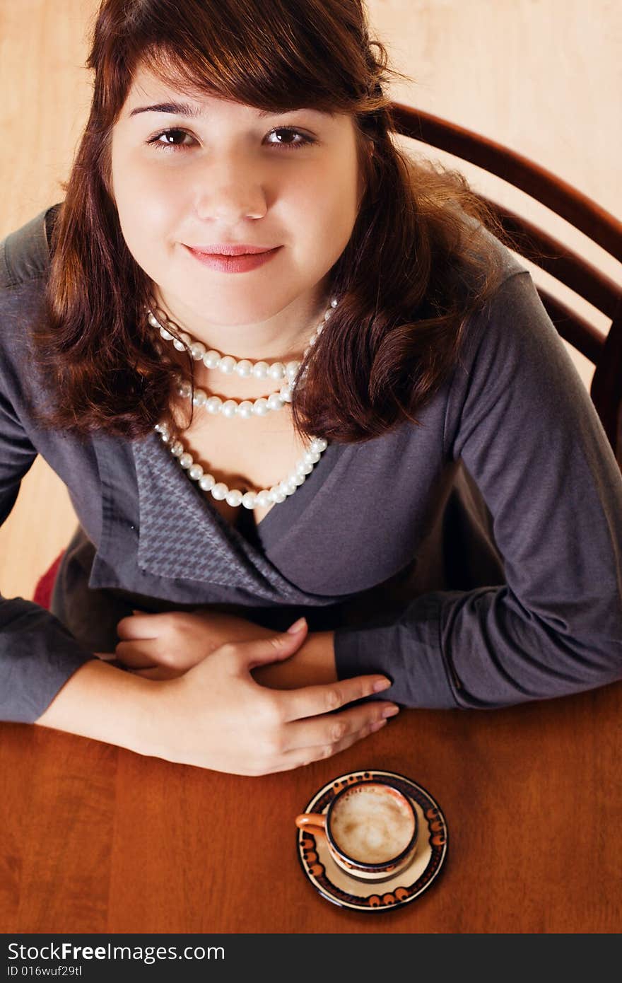 Young woman sitting by the table