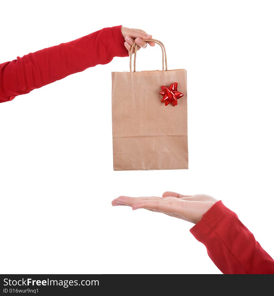 Woman hand holding papper bag with red ribbon isolated on white background