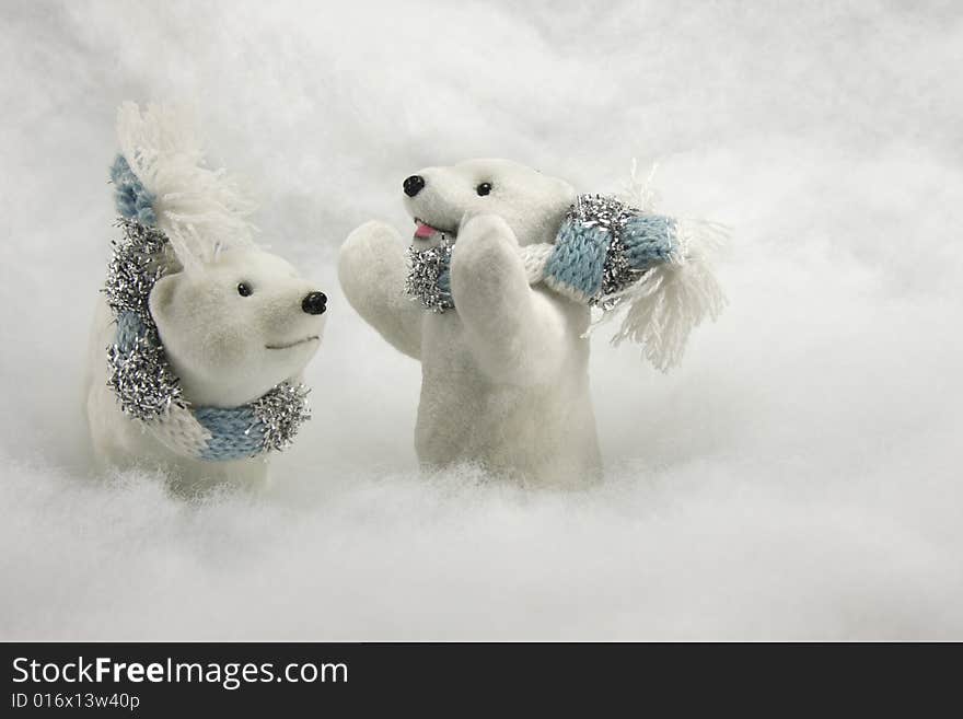 Pair of Polar Bear ornaments with wool scarves tied around their necks against a snow background. Pair of Polar Bear ornaments with wool scarves tied around their necks against a snow background.