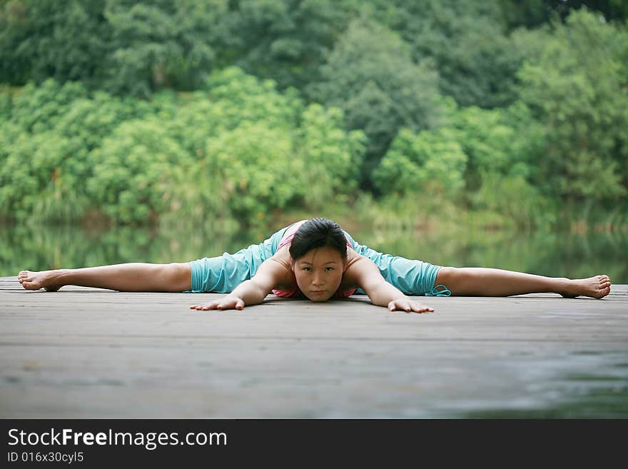 A young chinese woman practicing yoga in the outdoors. A young chinese woman practicing yoga in the outdoors