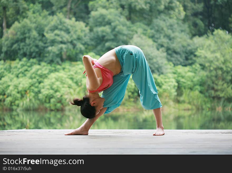 Young chinese woman practicing yoga outdoor