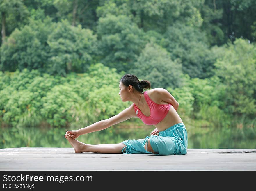 Young chinese woman practicing yoga outdoor