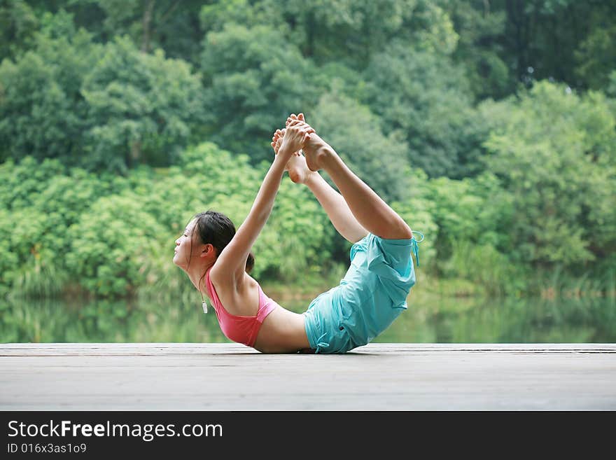 Young chinese woman practicing yoga outdoor