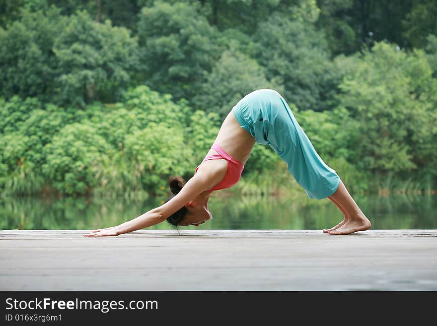 A young chinese woman practicing yoga in the outdoors. A young chinese woman practicing yoga in the outdoors