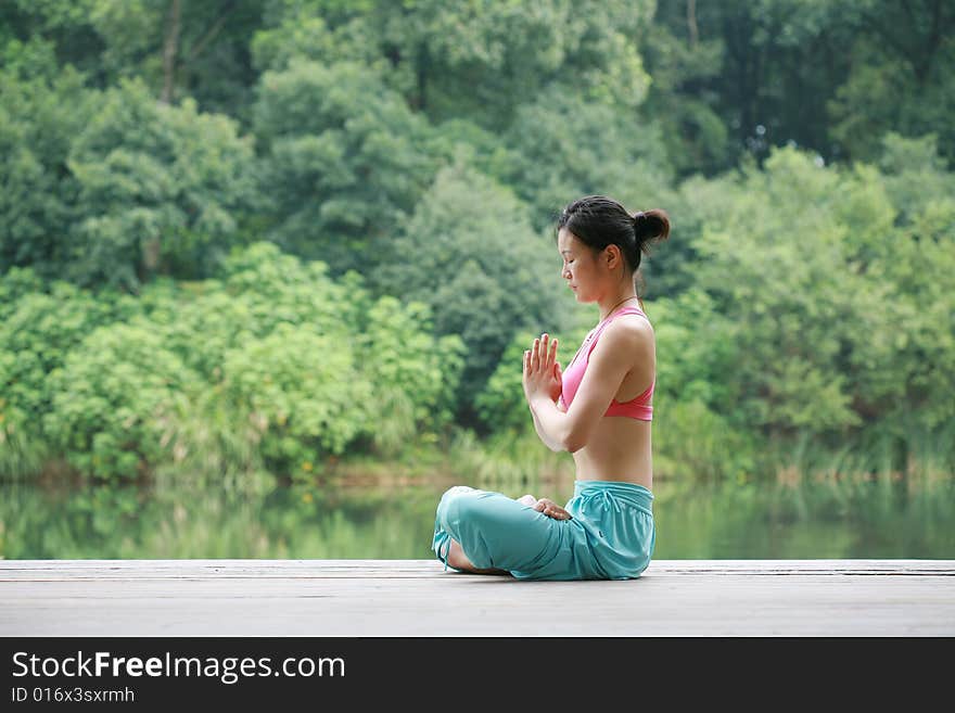 Young chinese woman practicing yoga outdoor