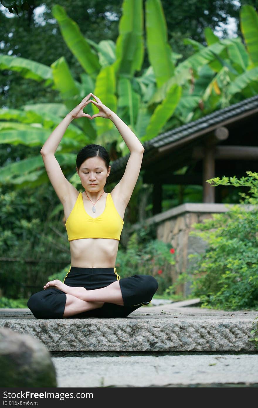 A young chinese woman practicing yoga in the outdoors. A young chinese woman practicing yoga in the outdoors