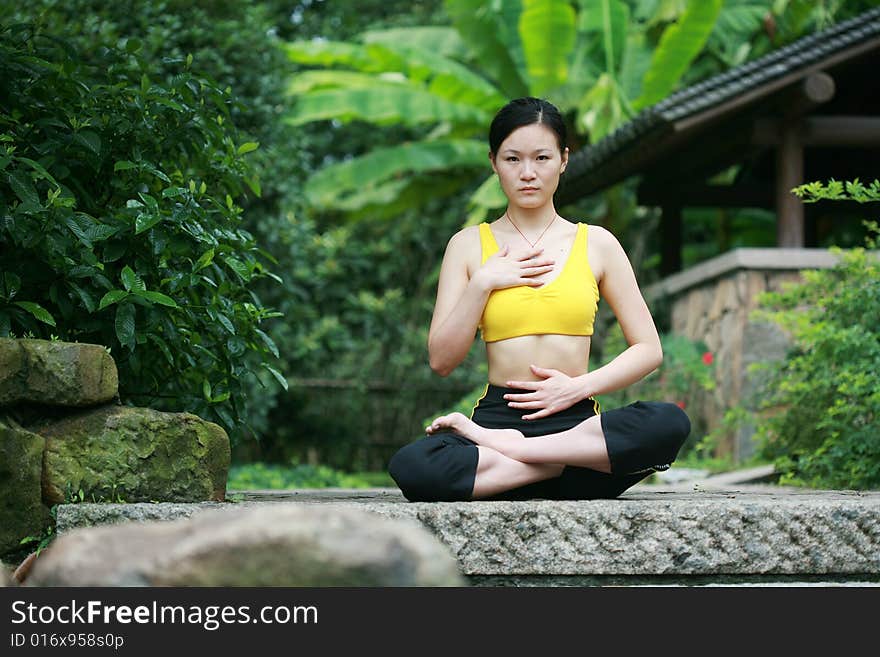 Young chinese woman practicing yoga outdoor