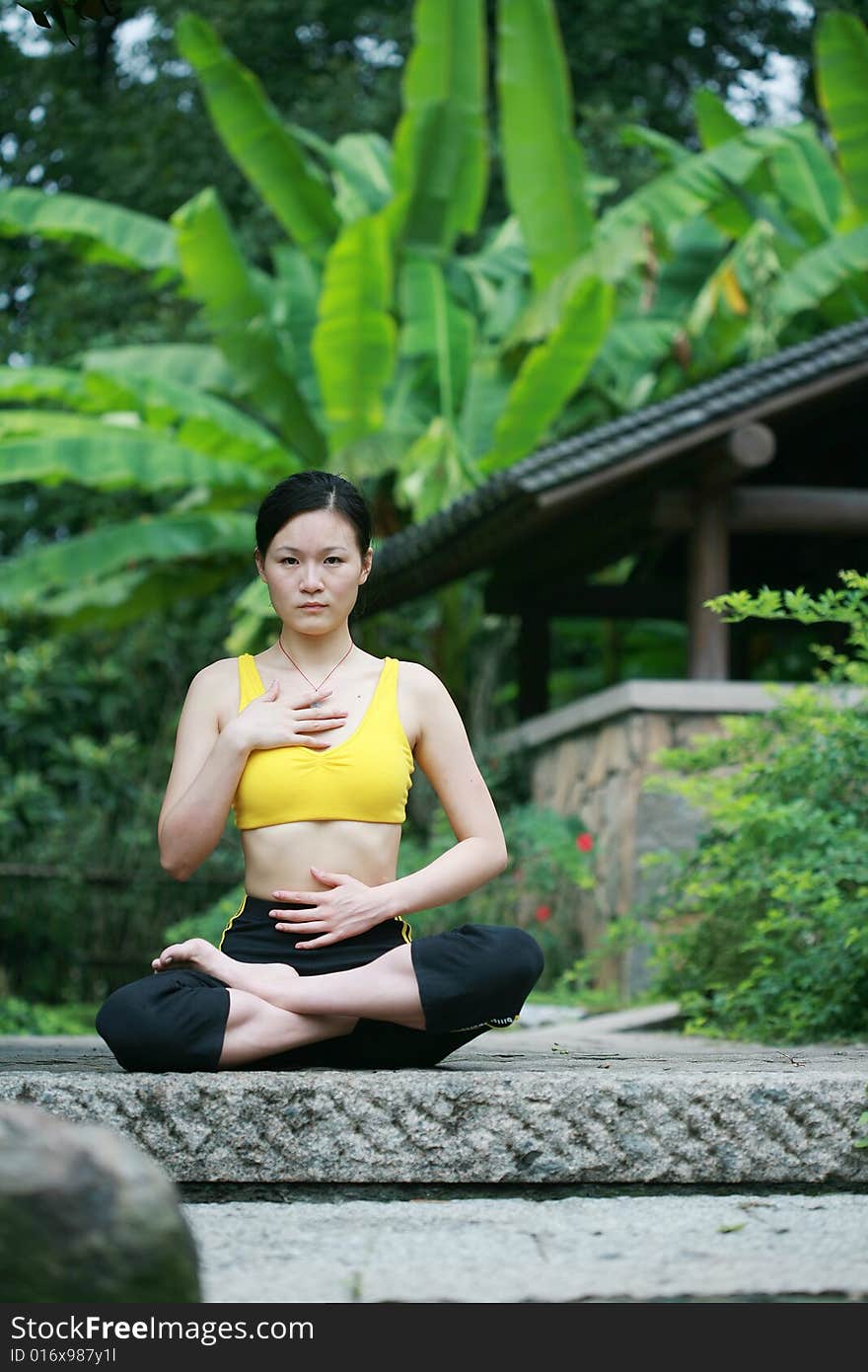 A young chinese woman practicing yoga in the outdoors. A young chinese woman practicing yoga in the outdoors