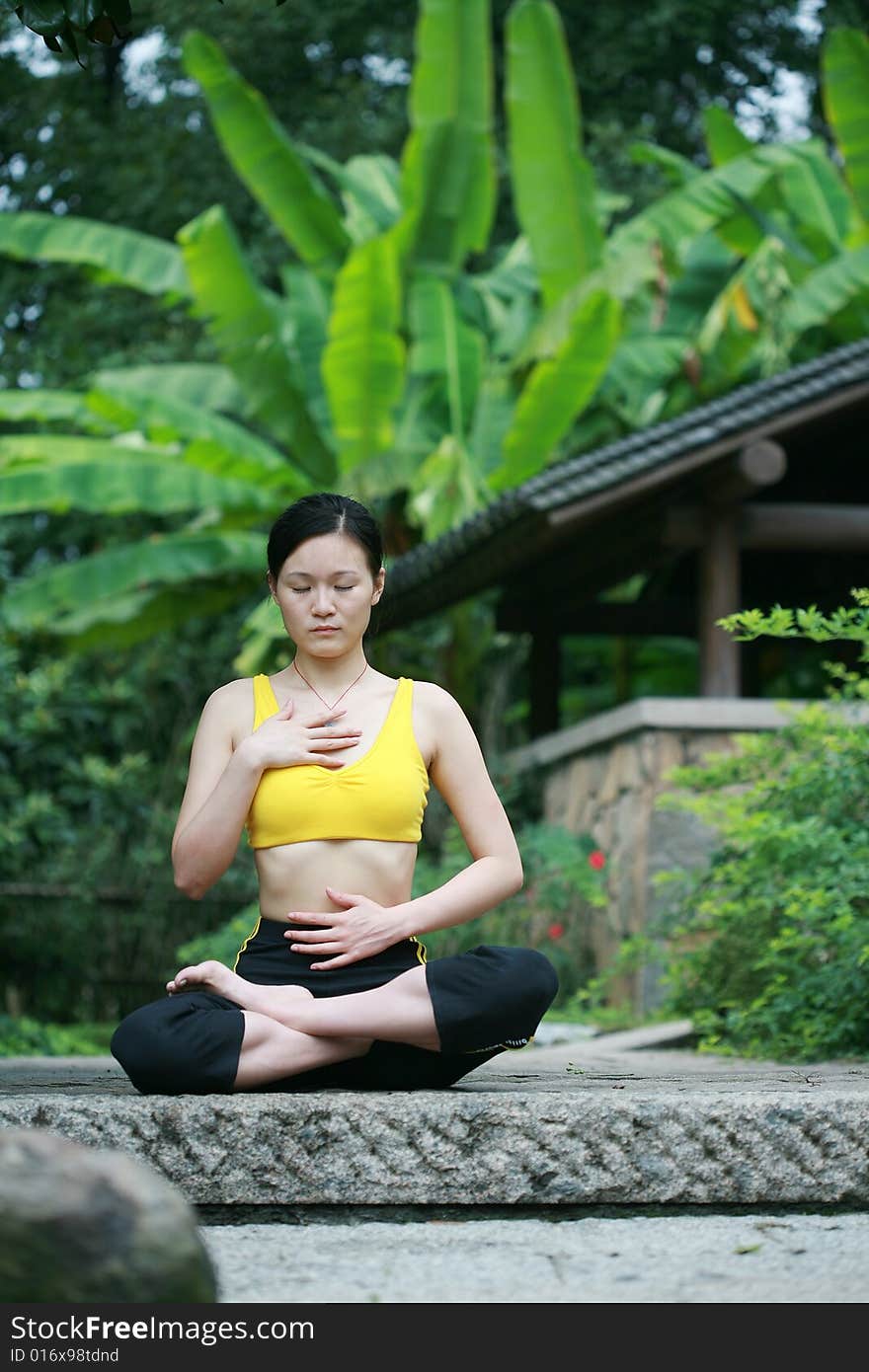 Young chinese woman practicing yoga outdoor