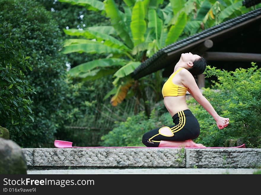 Young chinese woman practicing yoga outdoor