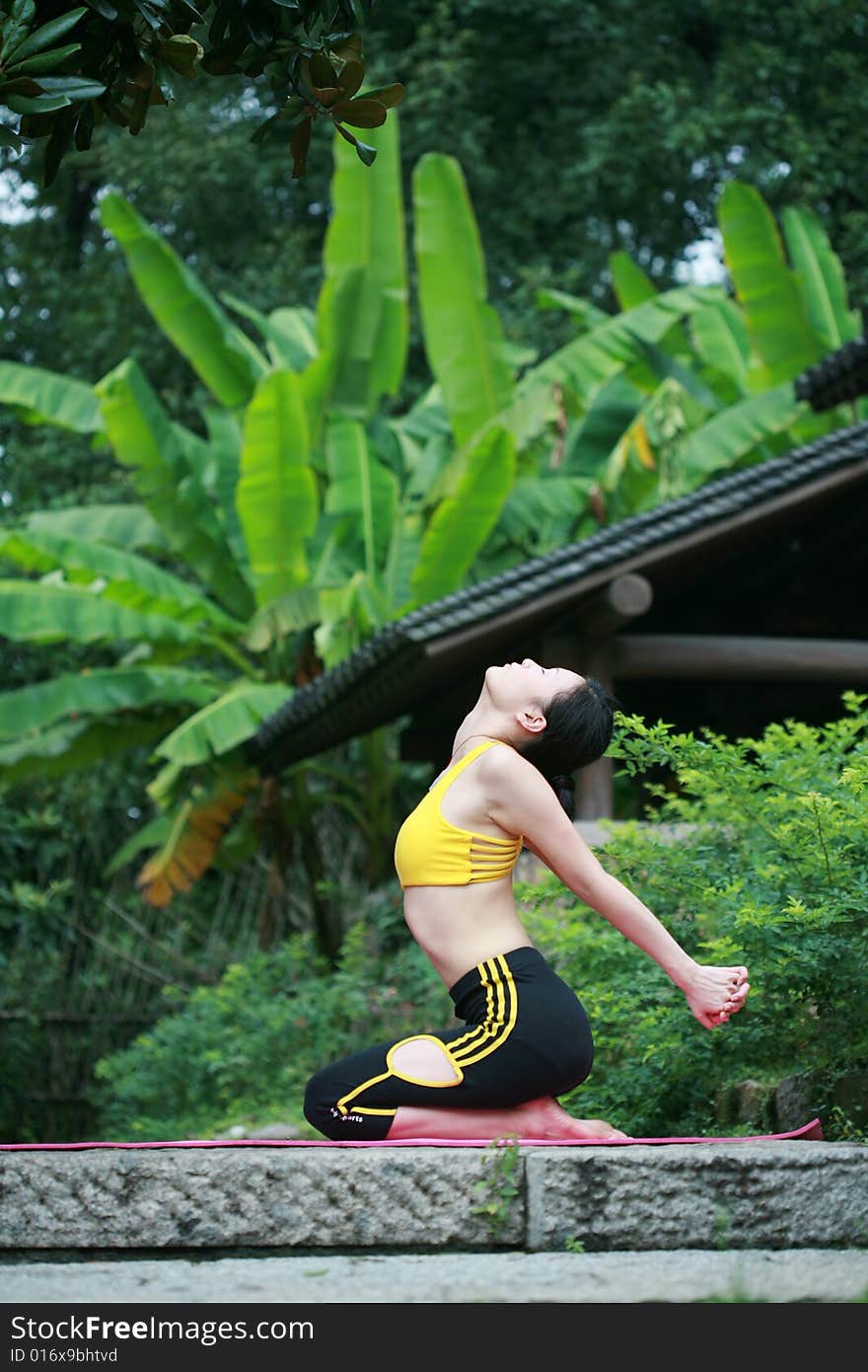 Young chinese woman practicing yoga outdoor