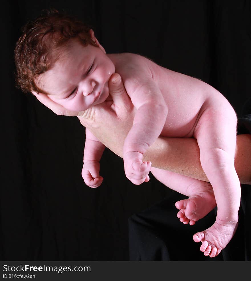 Little baby with a head full of hair on mommy's hand. Little baby with a head full of hair on mommy's hand