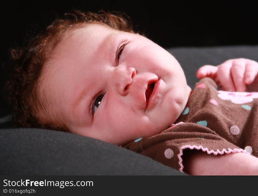 New born baby girl smiling at the camera. New born baby girl smiling at the camera