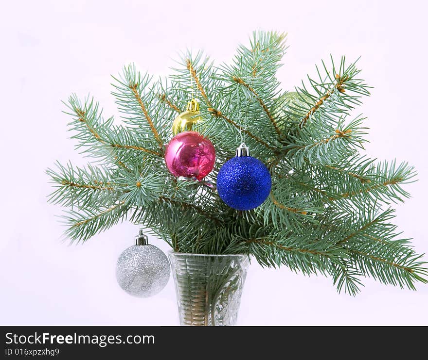 Branches of a blue spruce with Christmas balls in a vase