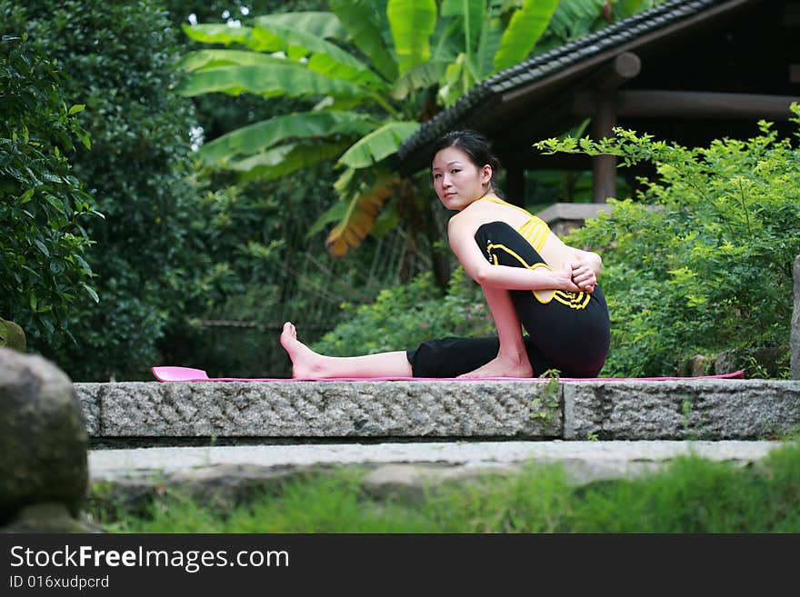 A young chinese woman practicing yoga in the outdoors. A young chinese woman practicing yoga in the outdoors