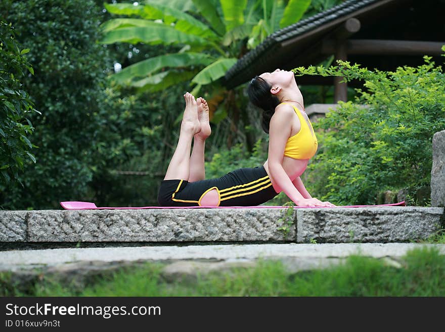 A young chinese woman practicing yoga in the outdoors. A young chinese woman practicing yoga in the outdoors