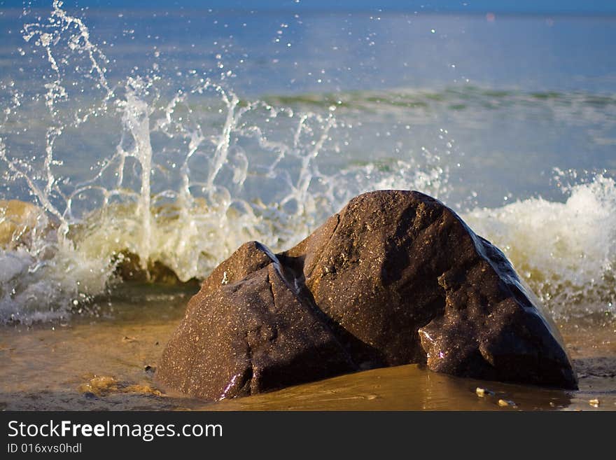 Sea coast, rock and water with waves