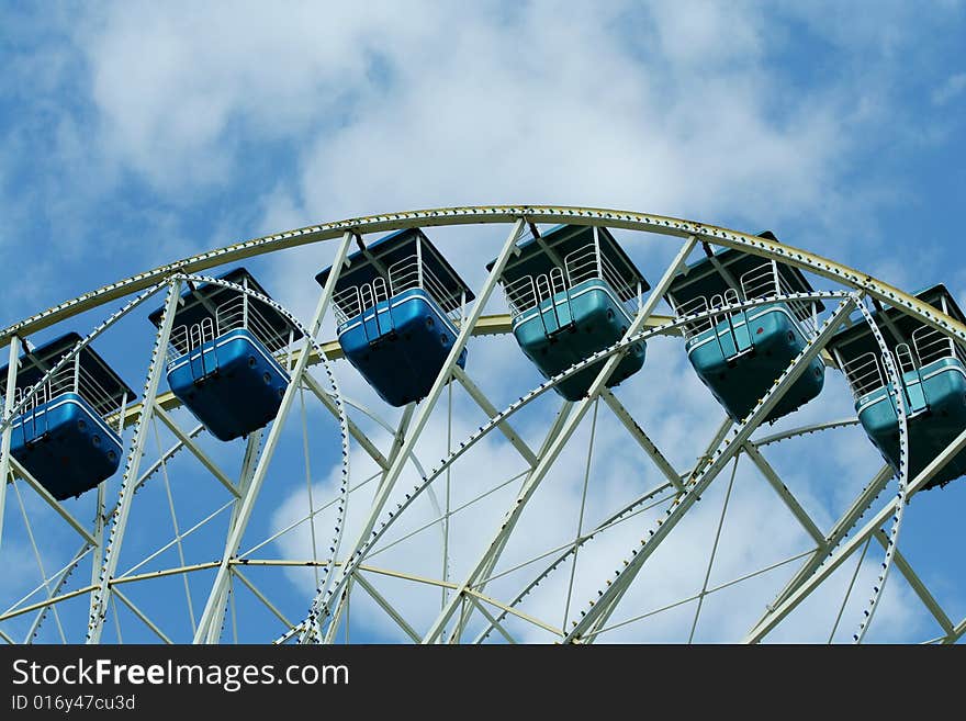 Ferris wheel against bule sky with clouds