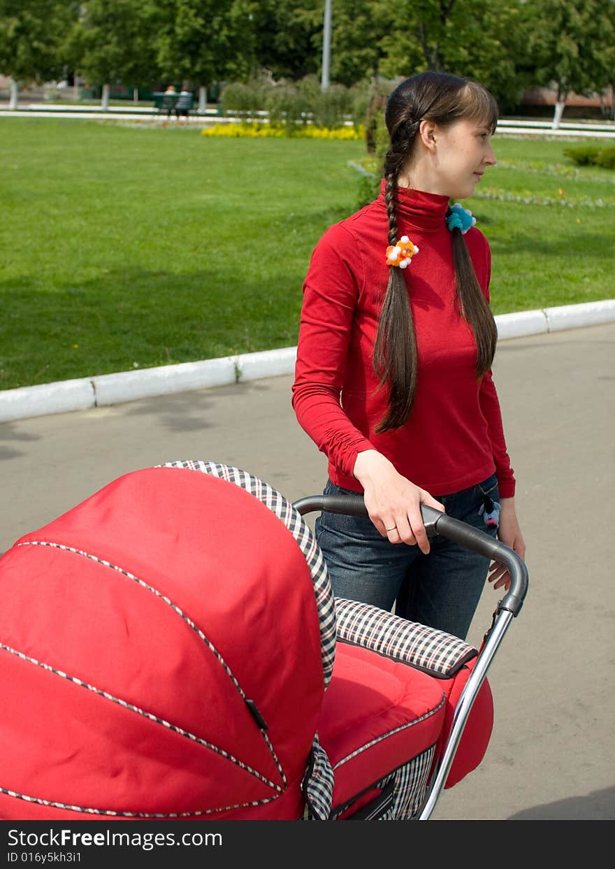 Young woman with red baby carriage. Young woman with red baby carriage