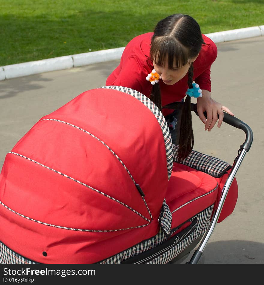 Young woman with red baby carriage. Young woman with red baby carriage