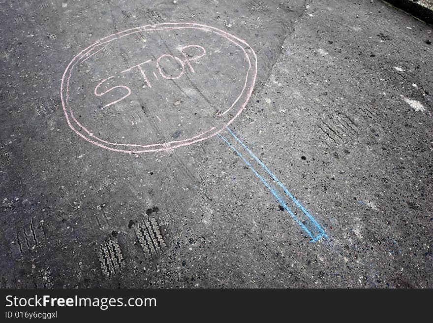 Stop sign made by kids by chalk on asphalt. Stop sign made by kids by chalk on asphalt