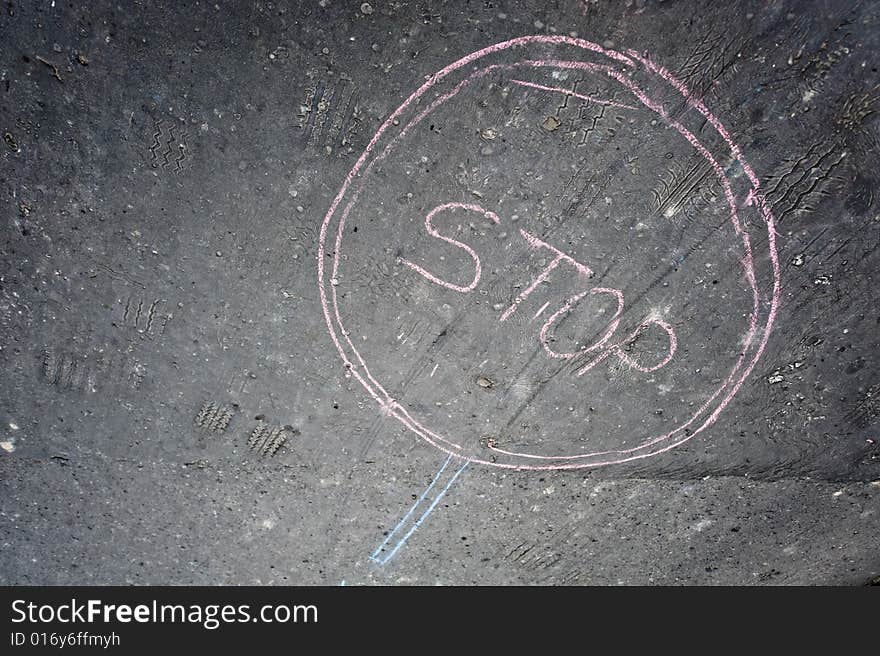 Painting of stop sign made written by chalk on asphalt. Painting of stop sign made written by chalk on asphalt