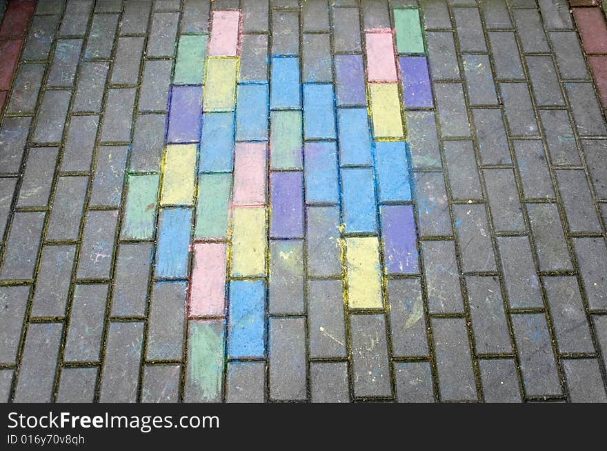 Perspective view of colorful kid's chalk drawing on pavement bricks