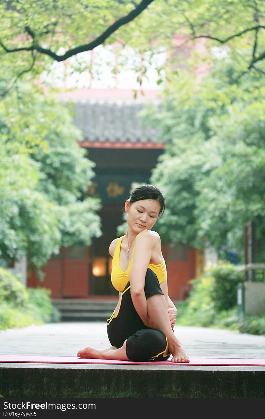 Young chinese woman practicing yoga outdoor