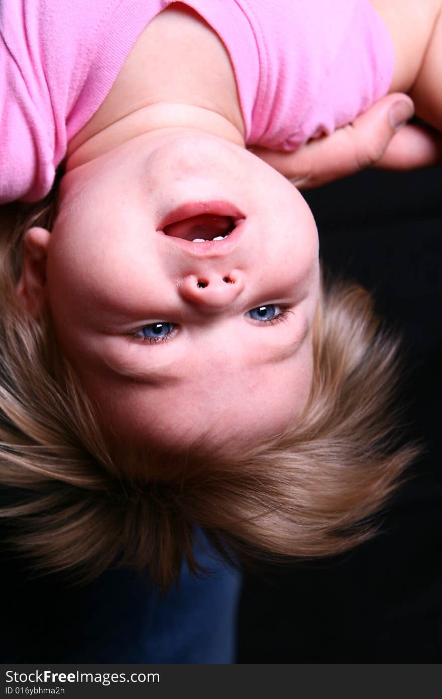 A sweet little girl hangs upside down and checks out life. A sweet little girl hangs upside down and checks out life.