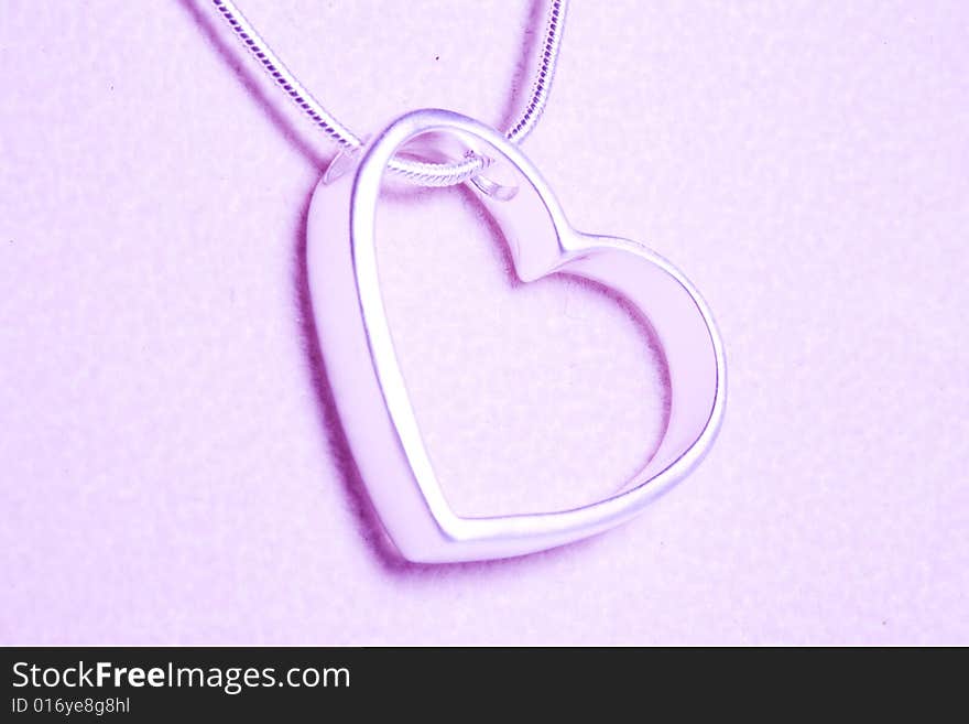 A hearts with Silvers and necklace isolated on the tint pink. A hearts with Silvers and necklace isolated on the tint pink