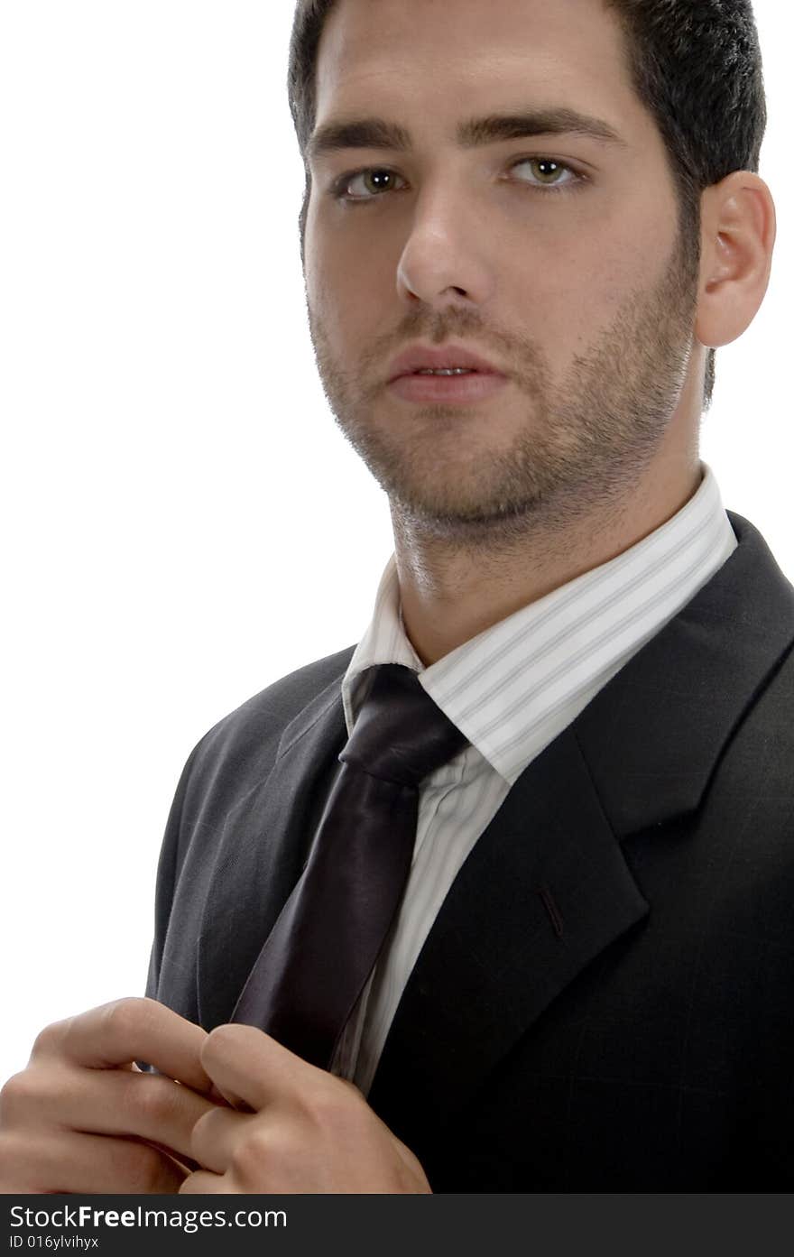 Businessman holding tie and looking to camera on an isolated white background