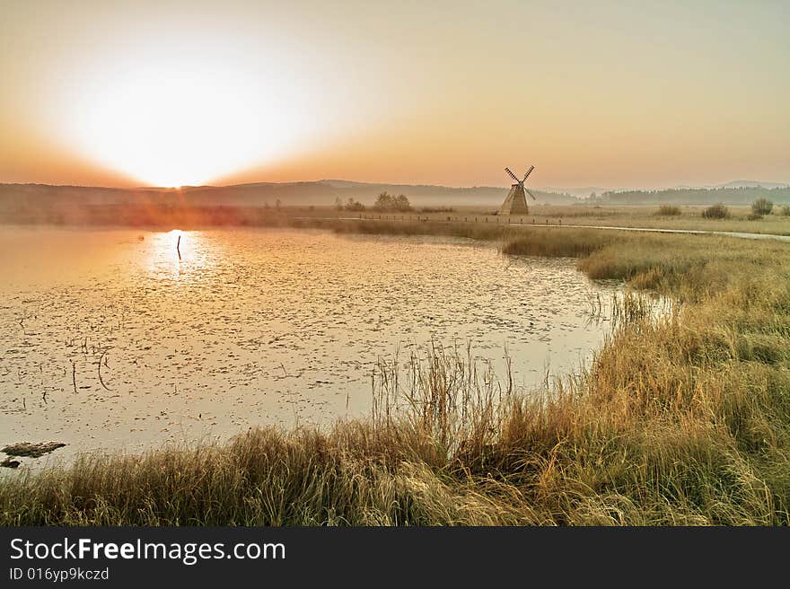 A bright sunrising is over a lake in autumn. A bright sunrising is over a lake in autumn.