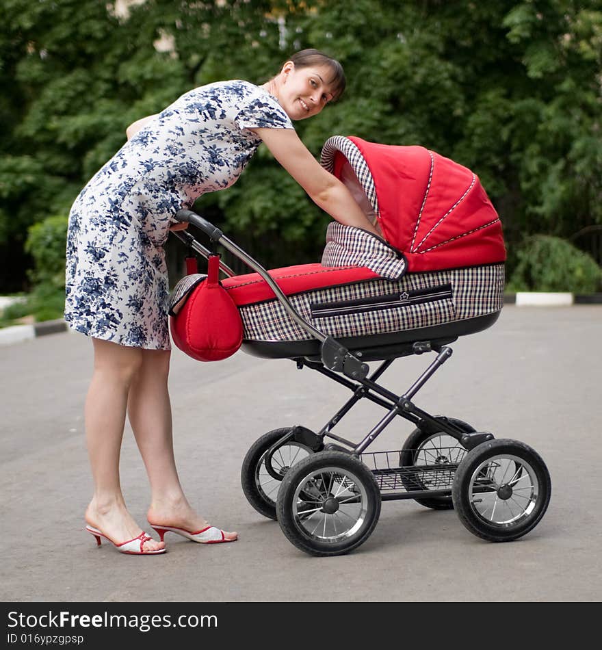 Young woman with red baby carriage. Young woman with red baby carriage